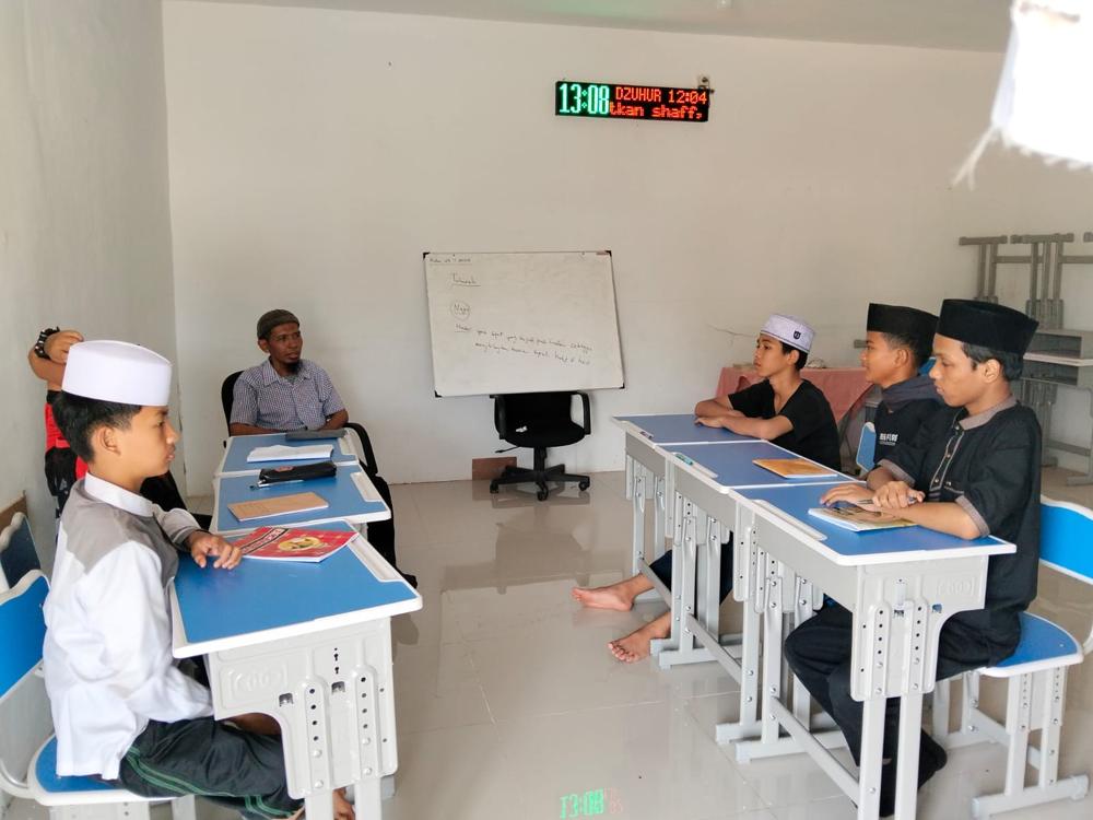 Ustadz mengajar materi thaharah kepada santri di ruang kelas